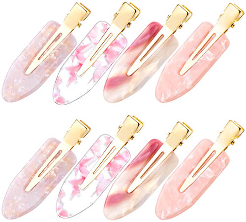 Eight pink iridescent barrettes with gold clasps on which background.