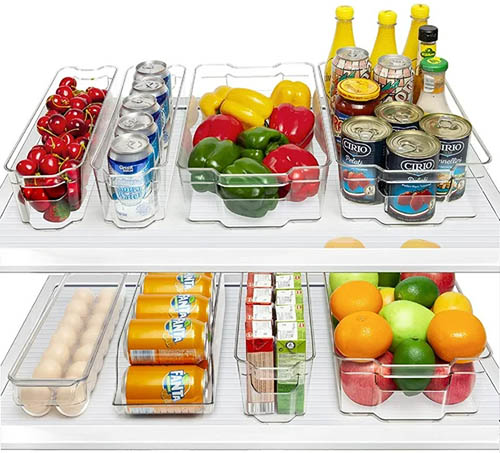 Fridge organizers with food and. drinks inside of them on two fridge shelves.