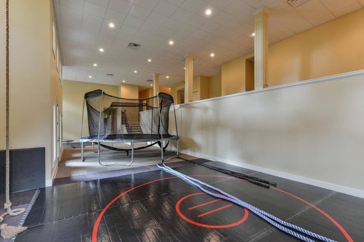 Basement with gym equipment and trampoline.
