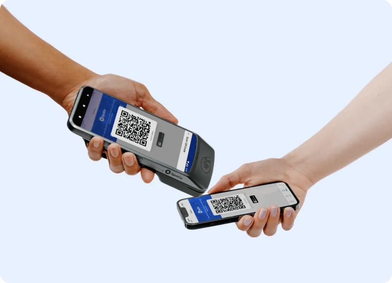 SpotOn handheld POS reading a QR code from a smartphone.