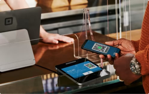 A customer smartphone scanning a QR code from a Square Register customer-facing display.