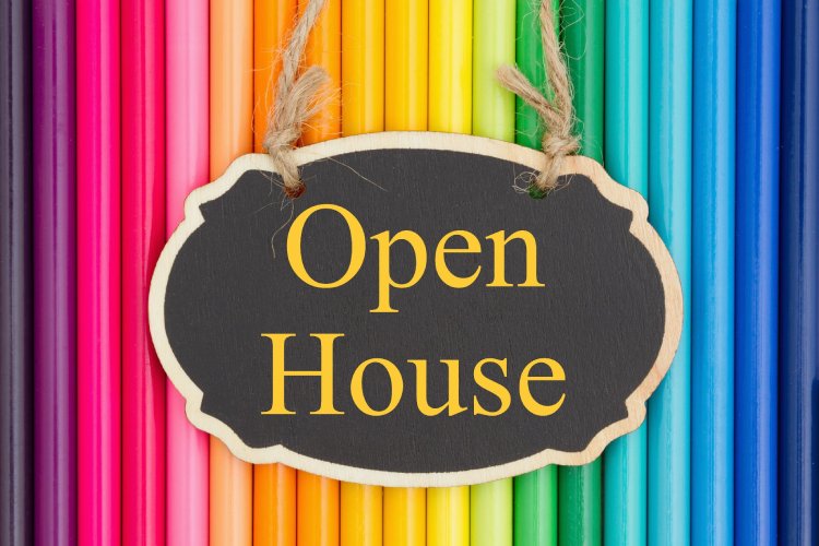 Open house sign on colorful backdrop.
