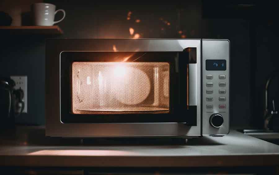 A silver microwave oven sitting on top of a counter.