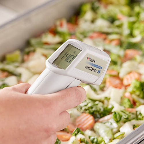Infrared thermometer reading the temperature of a tray of food.