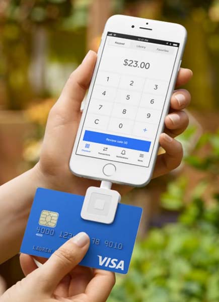 Square app on smartphone with card reader attachment.
