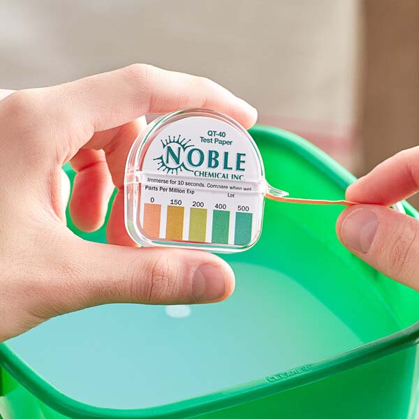 Testing a container of sanitizing solution with Noble Chemical test strips.