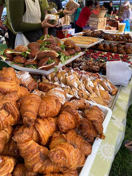 Farmer's market booth with a variety of pastries on display.