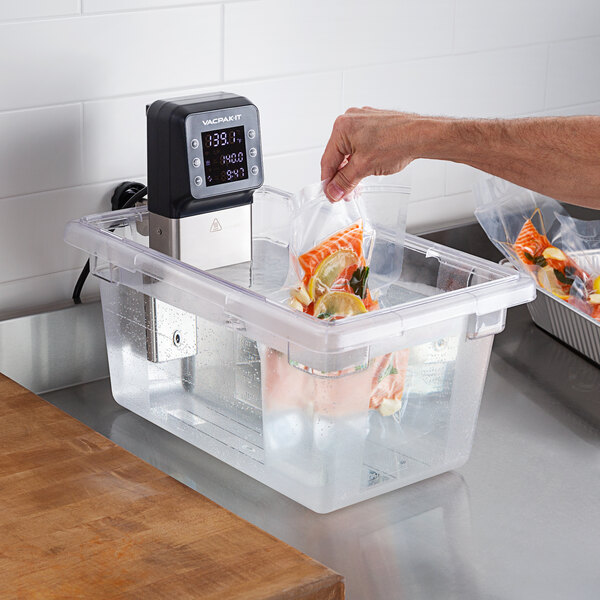 Putting a vacuum-sealed bag of food into a sous vide circulator.