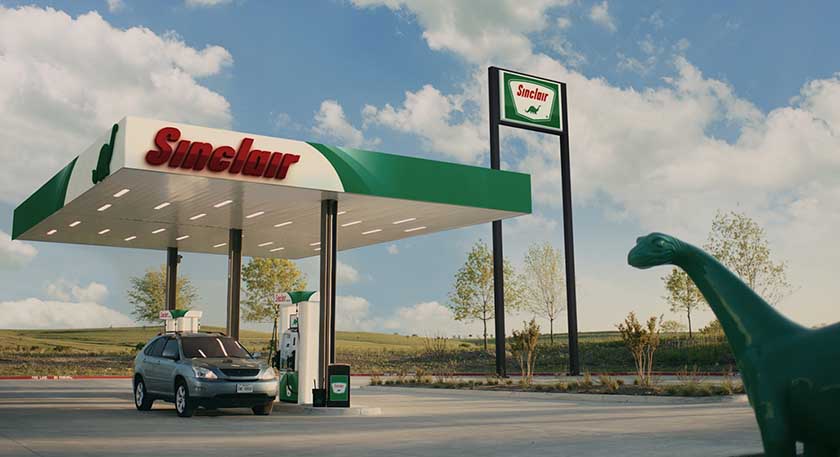 Sinclair gas station with a car parked at a pump and dinosaur mascot in the foreground.