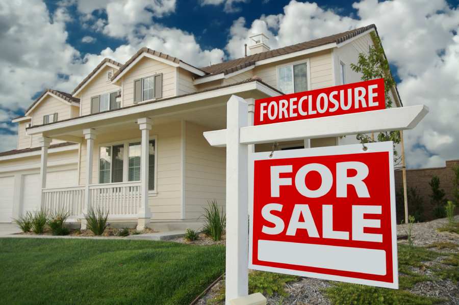 Foreclosure For Sale sign on a red background.