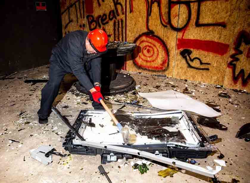 Man smashing items in the Rage Room Orlando.