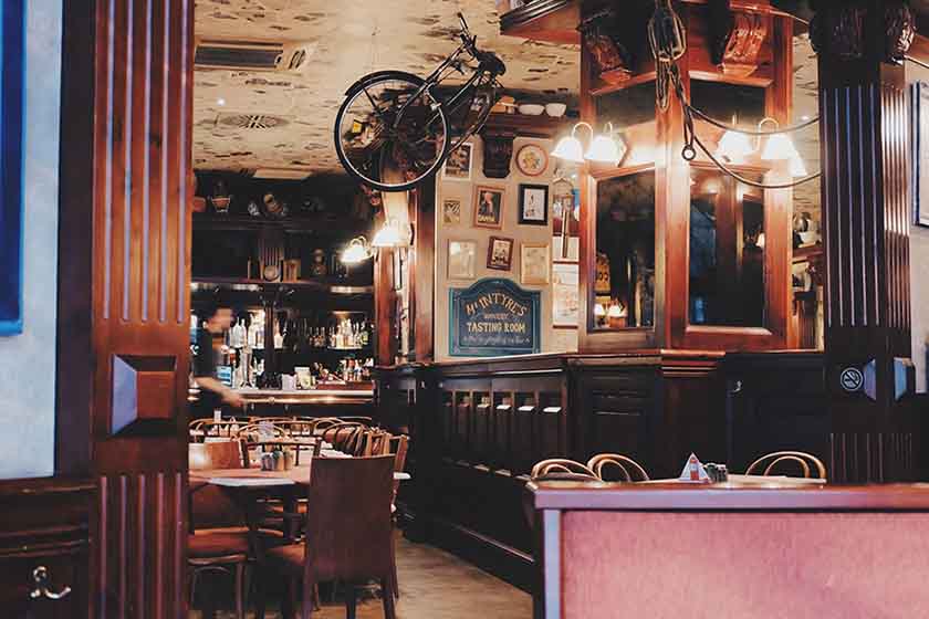 Bar with tables and a bike attached to the ceiling. Photo by donterase on Pixabay.