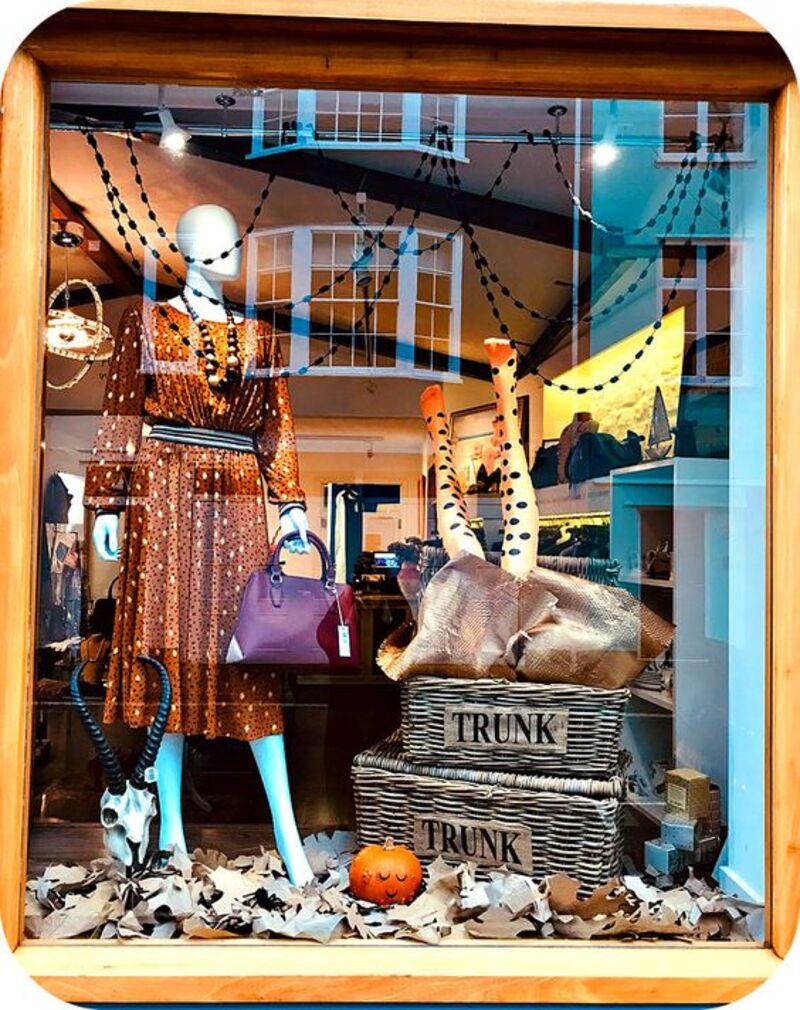 Halloween window display of a clothing store using themed garland
