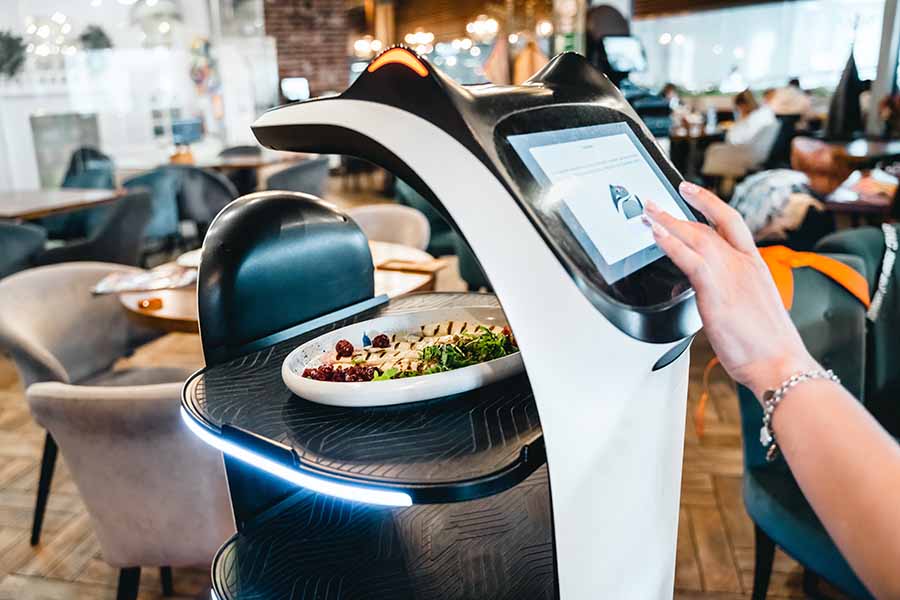 Robot waiter serve food at modern restaurant table.Offering innovation futuristic high-tech automated dining experience