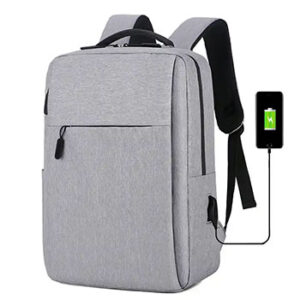 A gray backpack with black zippers and a phone plugged into a USB port in its side.