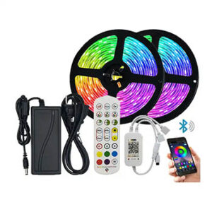 Two spools of multi-colored light strips next to a power cord, remote, and a hand holding a cell phone.