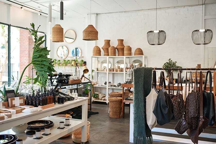 A clean, white store with earthy home decor, accessories, and scented goods for sale.