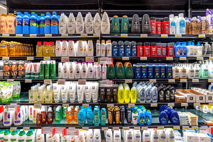 Store shelves with shower goods like shampoo, conditioner, and body wash.