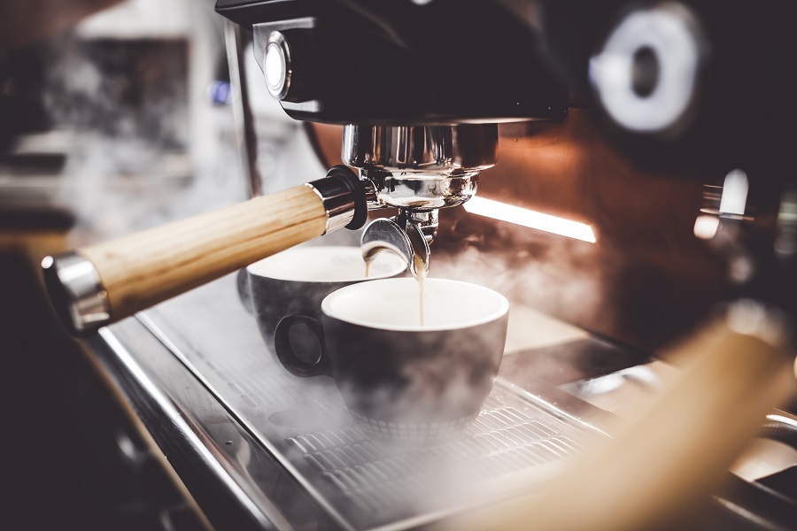 Espresso poruing from coffee machine at cafe.
