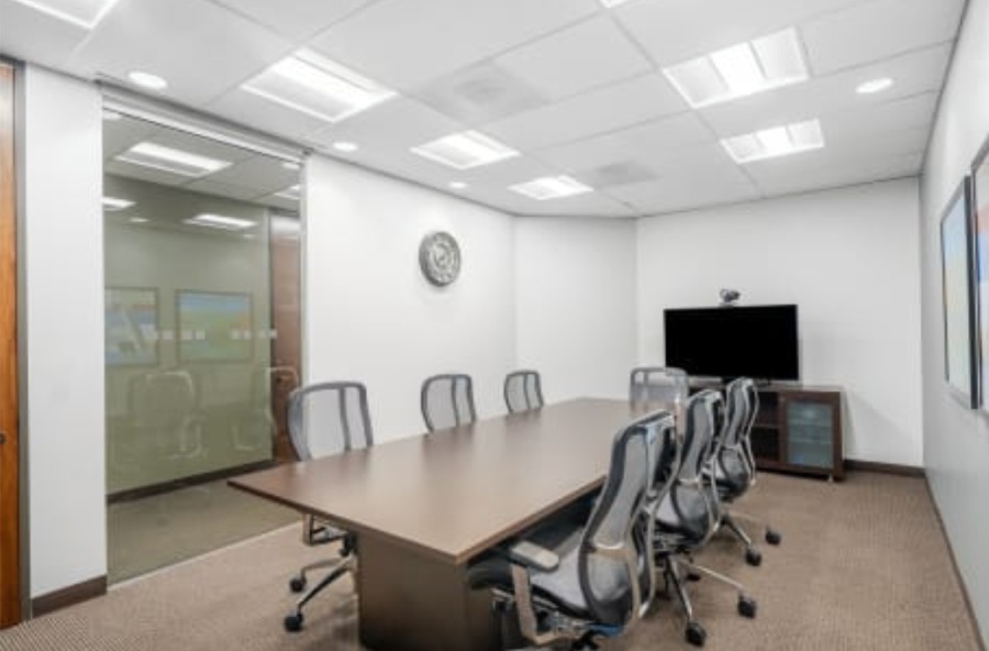 Large conference room with office chairs, TV with camera, and other meeting amenities.