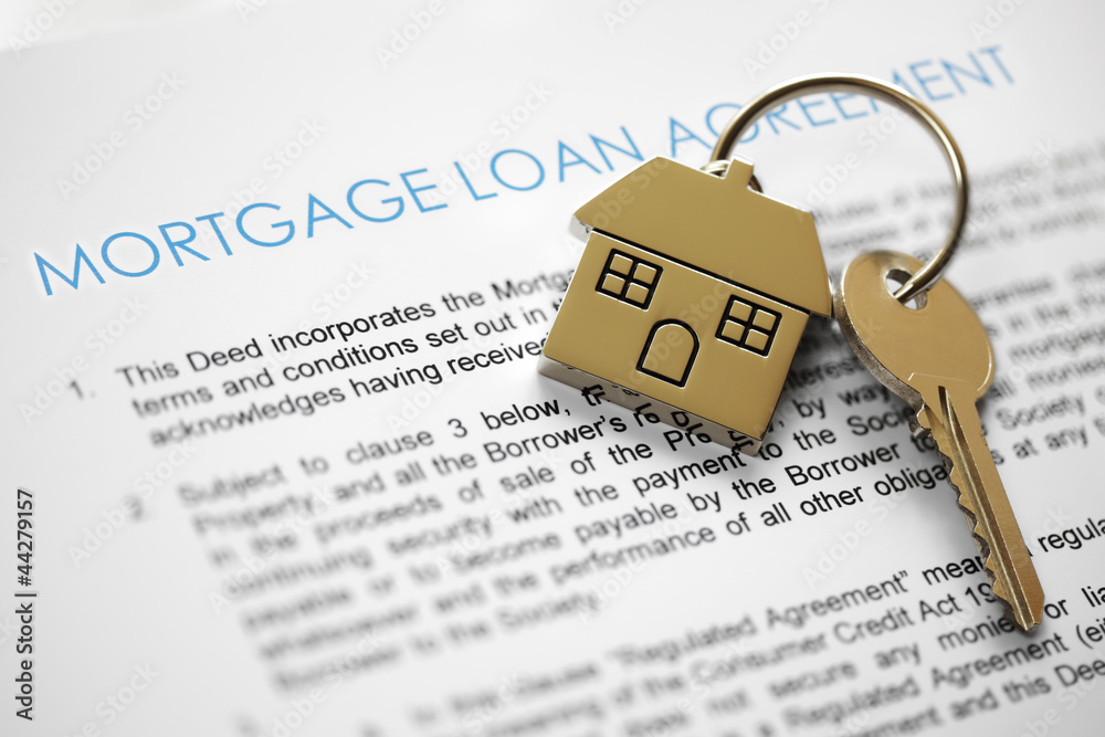 Mortgage loan agreement with a house key on top of it