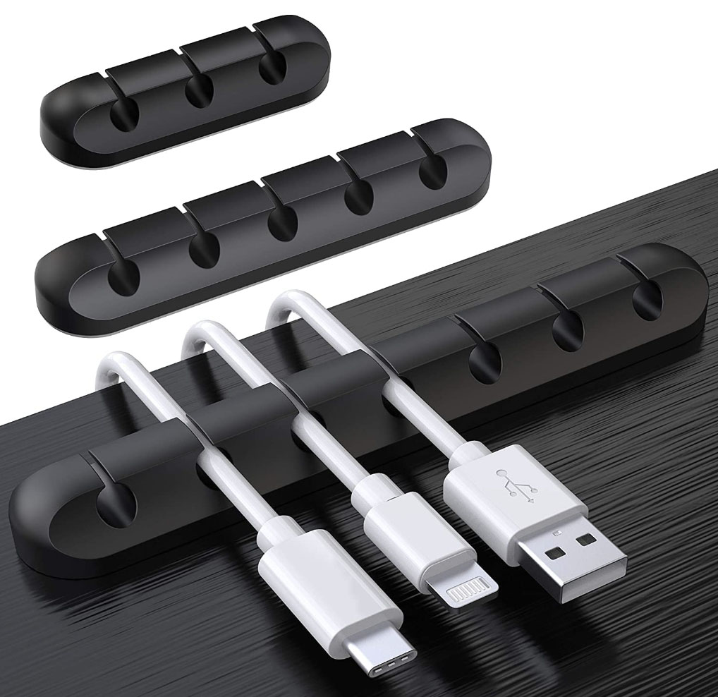 Black cable management strip with adhesive for organizing power, mouse, and cable chargers.