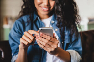 Smiling woman using smartphone.
