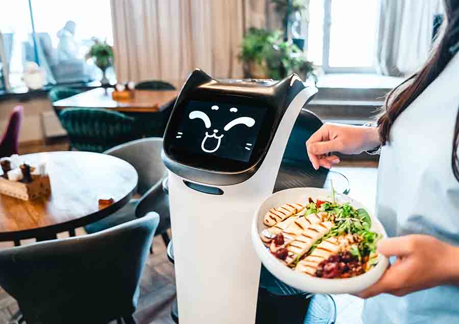 Robot waiter serve food at modern restaurant table.