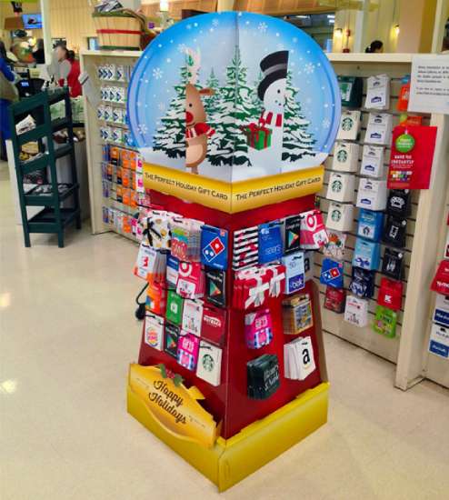 Gift card display that looks like a snow globe on a red stand. 