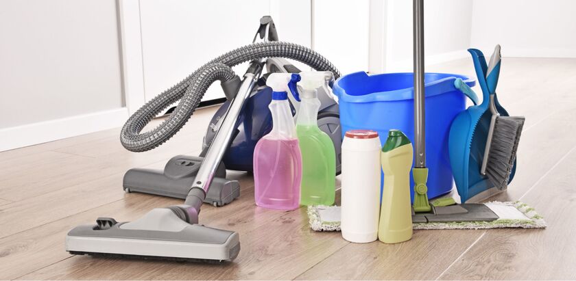 A vacuum, bucket, mop, dustpan, and various bottles arranged on a floor.
