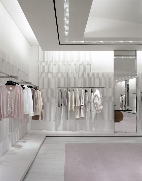 Sprase, grey store interior with a few pieces of clothing displayed on wall racks.