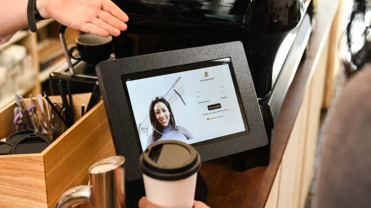 Mastercard facial recognition tech at a checkout terminal.