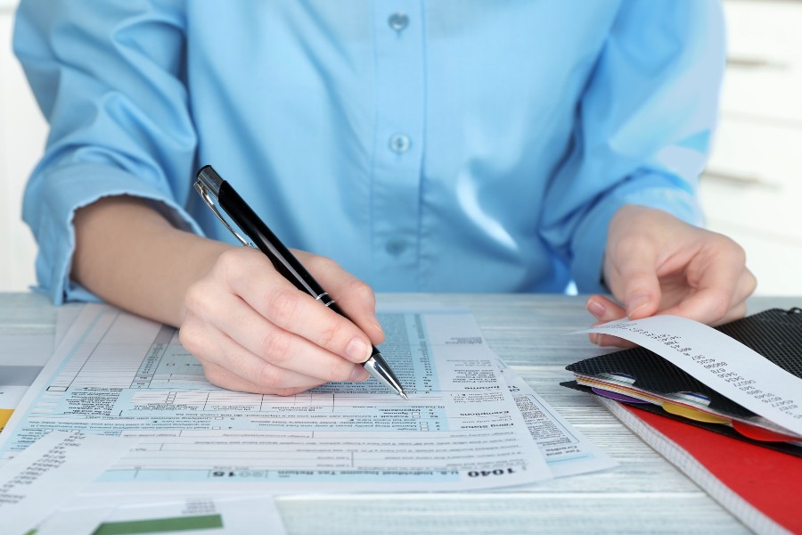 Woman filling form of Individual Income Tax Return, closeup.