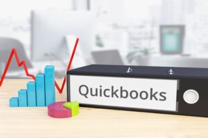Quickbooks – Finance/Economy. Folder on desk with label beside diagrams. Business/statistics. 3d rendering
