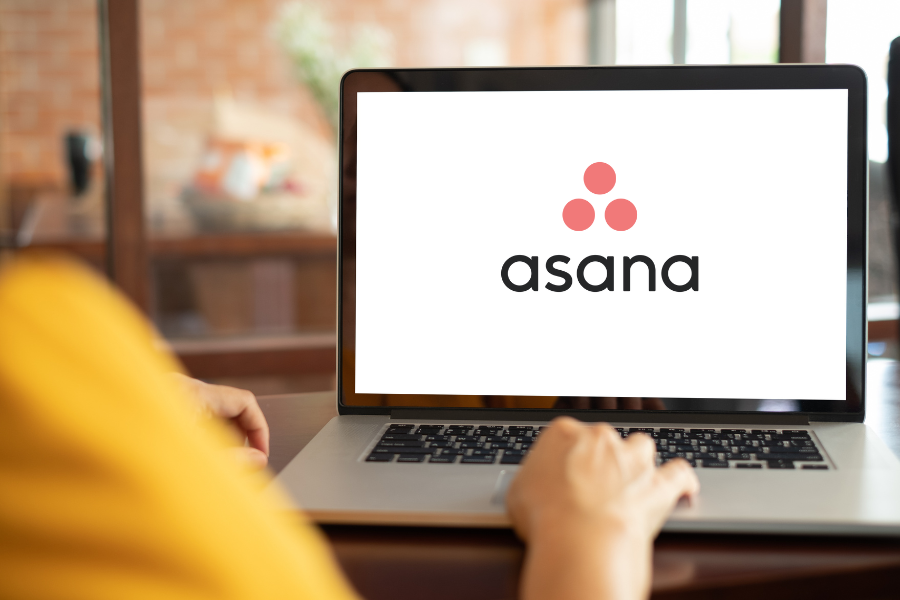 A laptop displaying the Asana logo.