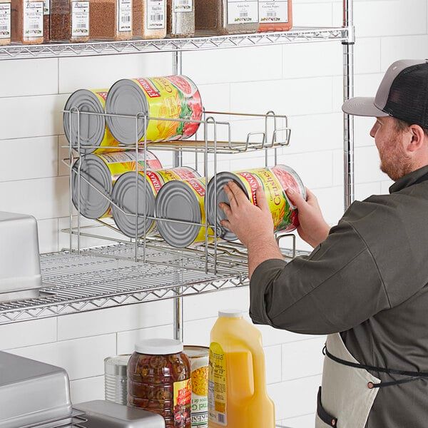 Chef arranging large cans of crushed tomatoes on a rack.