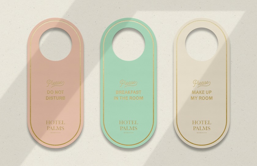 Door hangers designed with Hotel Palms' branding.