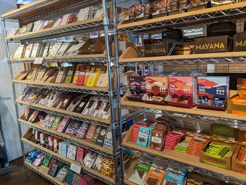 A set of grocery store shelves containing over 100 different chocolate bars in colorful labels.