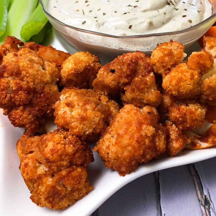 Cauliflower "wings" and a bowl of dipping sauce arranged on a plate