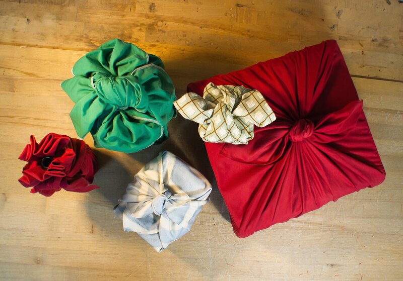 Five items of various sizes wrapped in colorful cloth in the Furoshiki style.