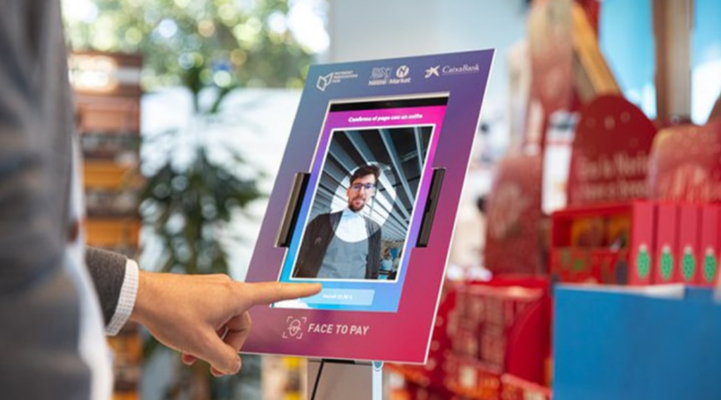 Man using a terminal with facial recognition technology to make a payment.