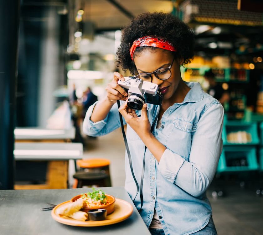 A photographer taking a picture of a plate of food.
