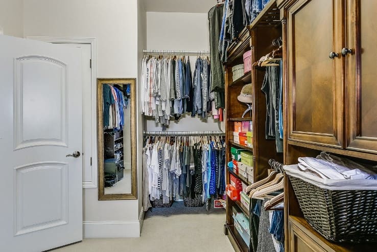 Walk in closet with clothes neatly organized