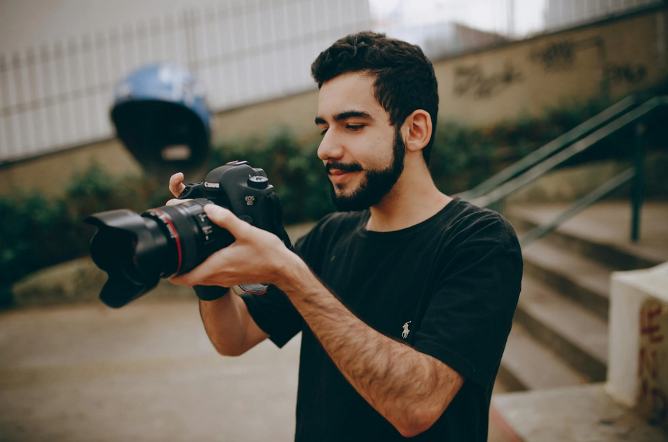 Young man using a DSLR camera in an urban area.