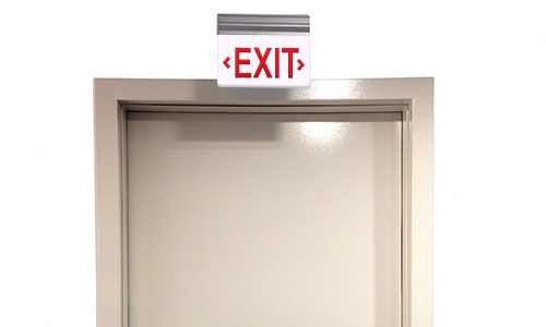 Picture of a door with an exit sign hanging above.