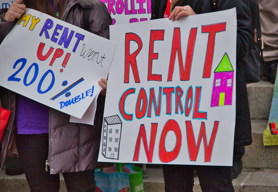 "Rent control now" signages held by people
