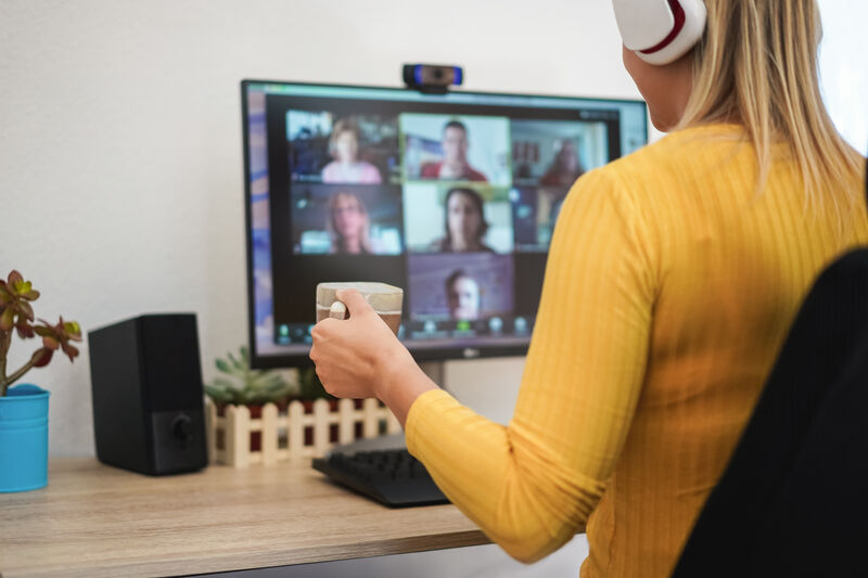 A young woman having a discussion meeting with her team via videoconference.