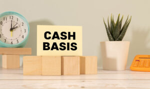 The word cash basis written on a notepaper on business office desktop.
