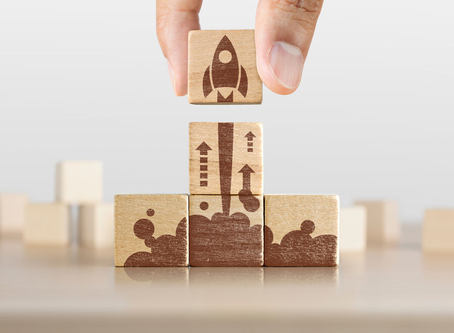 Wooden blocks with launching rocket graphic arranged in pyramid shape