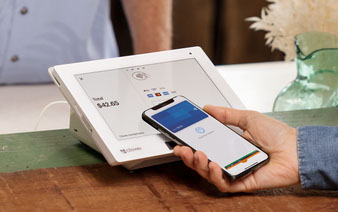 Clover Mini POS system accepting payment from a smartphone.